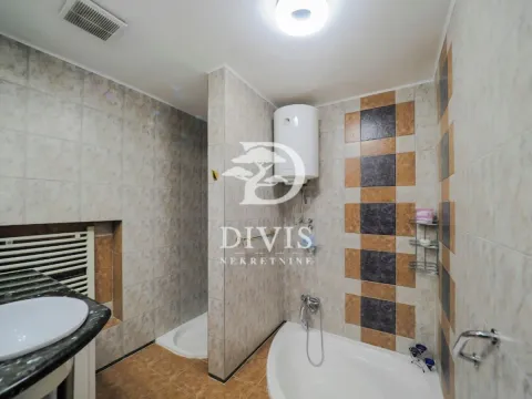 Bathroom equipped with a bathtub, shower cabin, washbasin, and water heater. - image 19