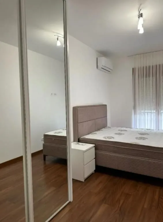Bedroom with a double bed, bedside table, and a built-in mirrored wardrobe.
