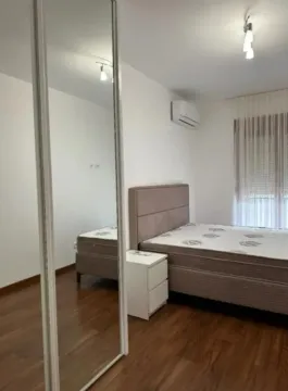 Bedroom with a double bed, bedside table, and a built-in mirrored wardrobe. - image 4