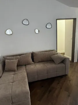Dnevna soba sa ugaonom garniturom i dekorativnim ogledalima na zidu. - image 13