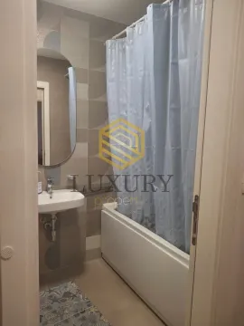 Small bathroom with a sink, mirror, and bathtub with a curtain. - image 7