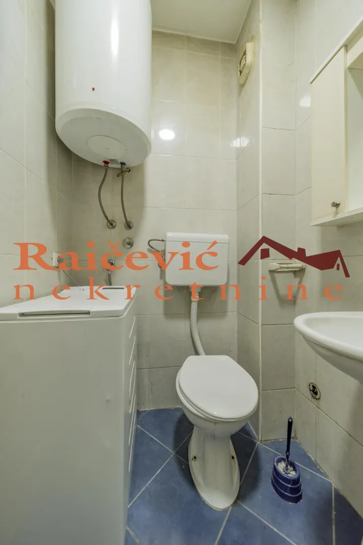 Manje kupatilo sa sanitarijama, bojlerom i veš mašinom.