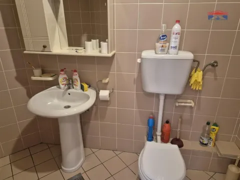 Kupatilo obloženo keramičkim pločicama sa umivaonikom i WC šoljom. - image 9
