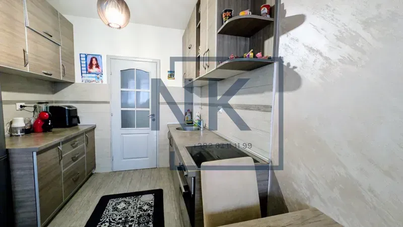 Smaller kitchen with wooden cabinets and a white door.