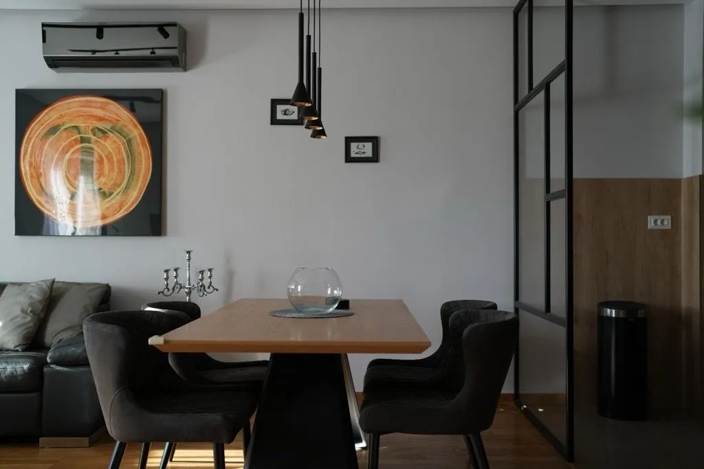 Modern dining area with a wooden table and dark chairs.