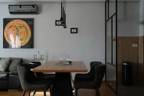 Modern dining area with a wooden table and dark chairs. - image 3