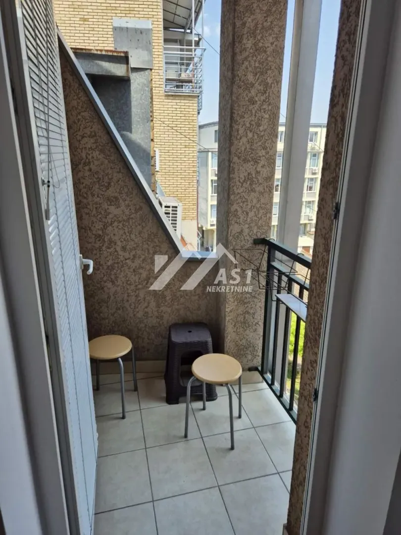 Manji natkriveni balkon sa keramičkim pločicama i stolicama.