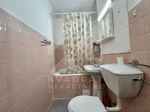 Tiled bathroom equipped with a bathtub, washbasin, and toilet. - image 8