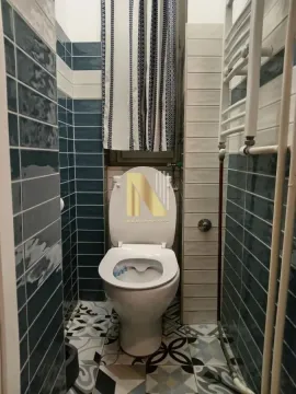 Manje kupatilo sa WC šoljom i plavim pločicama. - image 9