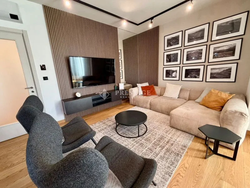 Living room with a sofa, TV, and decorative wall panels.