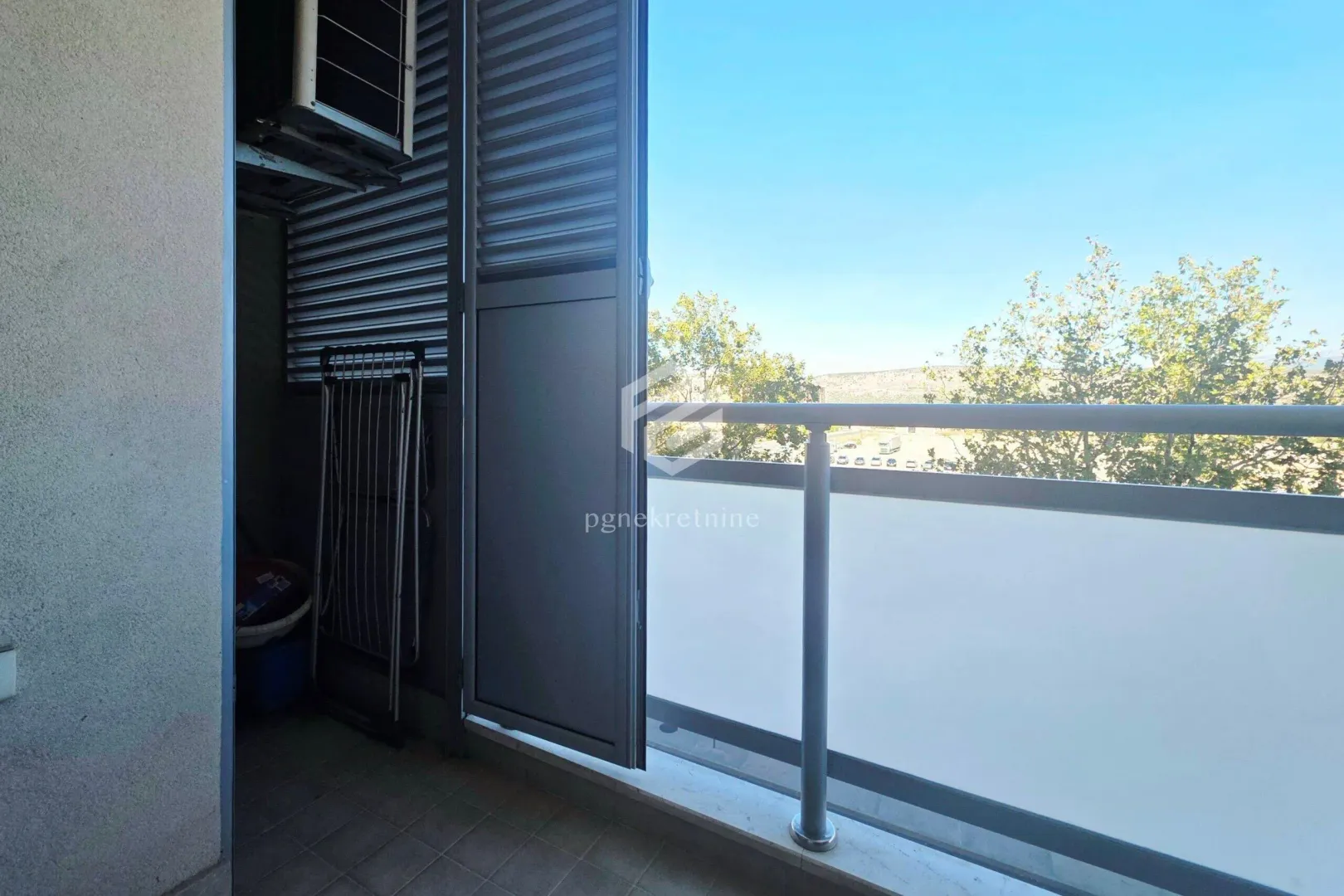 View from the balcony with metal railing and roller blinds.