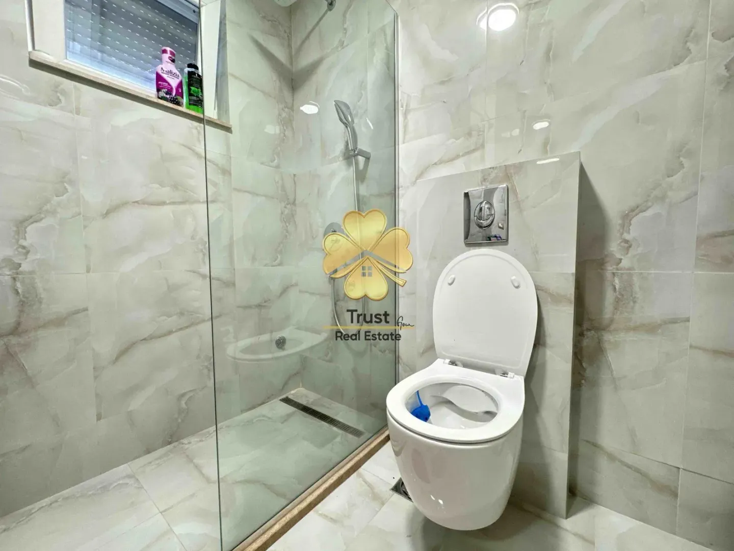 Modern bathroom with a walk-in shower and a wall-hung toilet.