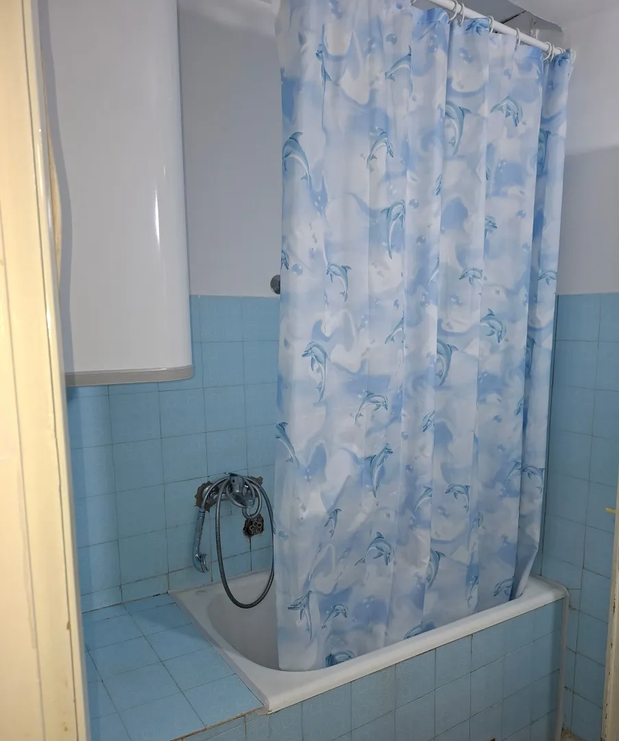 Bathroom with a bathtub and blue tiles.