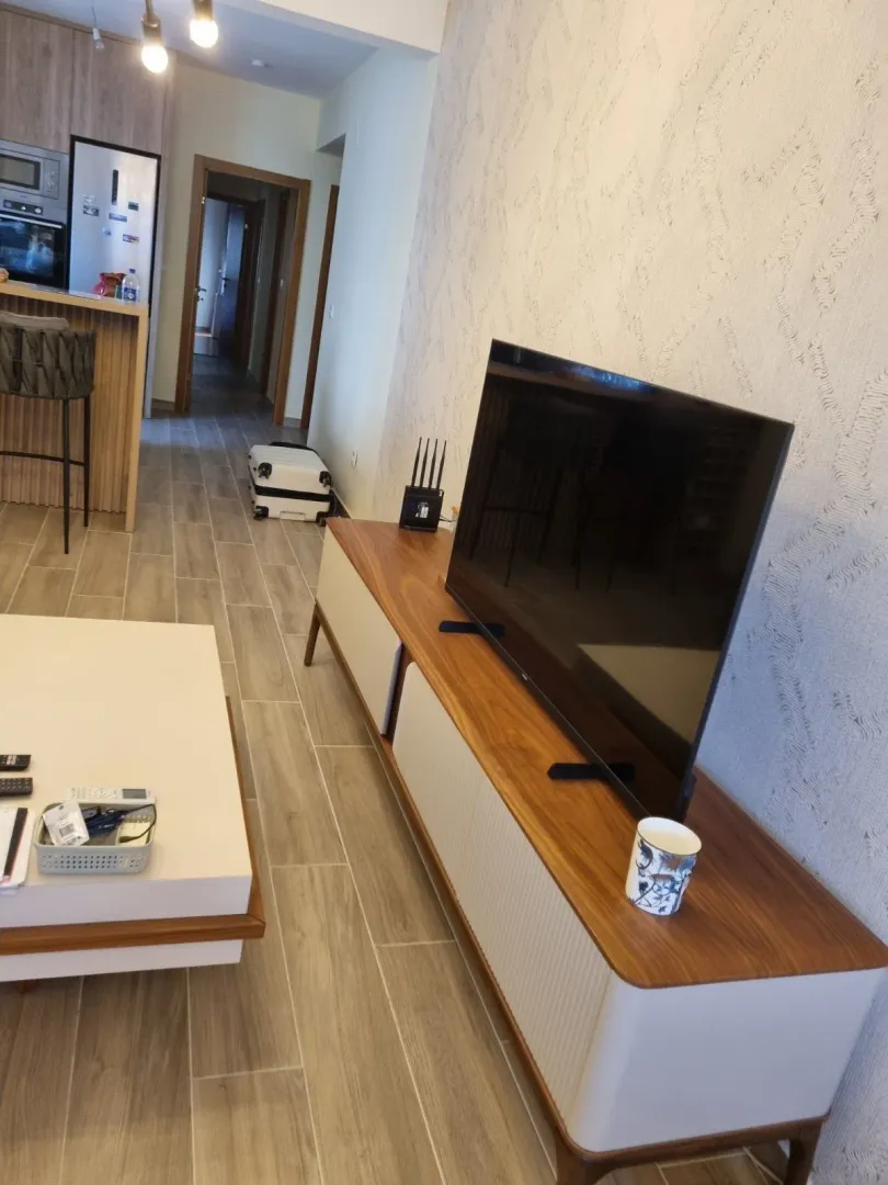 Dnevna soba sa TV komodom i hodnikom.