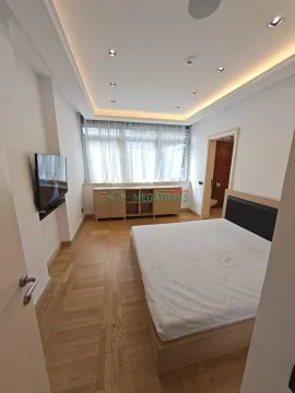 Prostrana spavaća soba sa bračnim krevetom, drvenim podom i velikim prozorom. - image 15