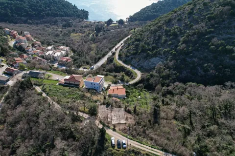 Pogled iz vazduha na prirodu, kuće i put okružen zelenilom. - image 3
