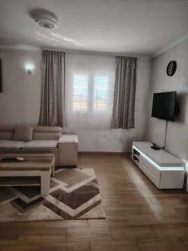 Living room with a sofa, coffee table, and wall-mounted TV. - image 3
