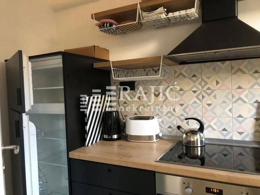 Small equipped kitchen with wooden countertops and appliances.