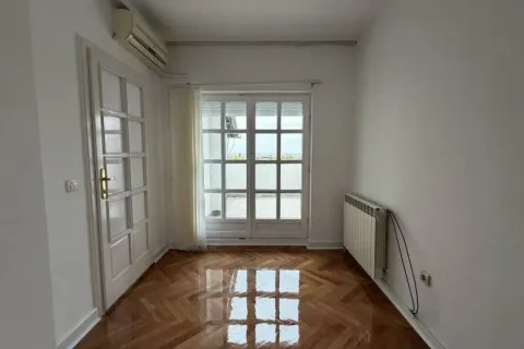 Prazna prostorija sa parketom, klima uređajem i balkonskim vratima koja vode na terasu. - image 8