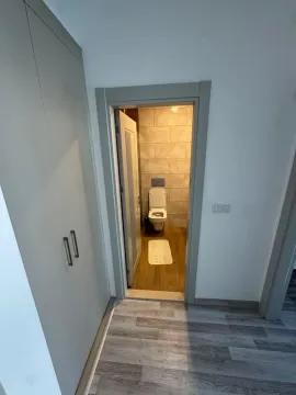 Pogled iz hodnika na kupatilo sa ugradnim ormarom i pločicama. - image 4