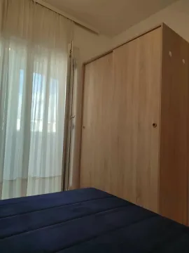 Spavaća soba sa ormarom i krevetom pored prozora sa svijetlim zavjesama. - image 7