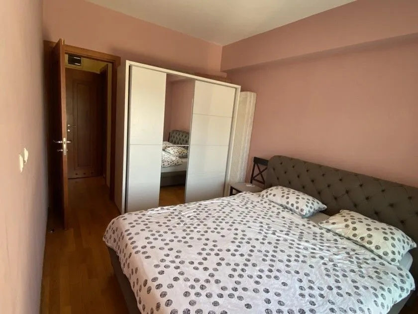 Bright bedroom featuring a double bed and a large wardrobe with mirrored doors.