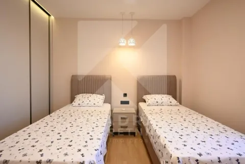 Bedroom with two single beds and a built-in wardrobe. - image 8