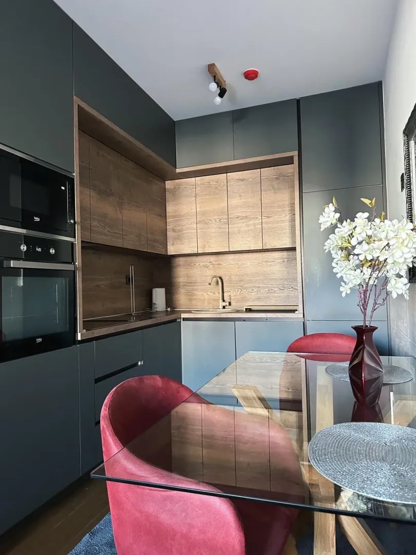 Modern kitchen with built-in appliances and a dining table.