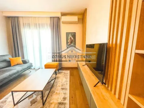 Dnevna soba sa garniturom, televizorom i drvenim detaljima na zidu. - image 2