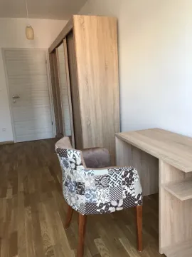 A room featuring a wooden desk, a patterned armchair, and a large wardrobe. - image 2