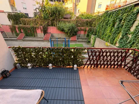 Terrace with tiled flooring and artificial greenery fencing overlooking the courtyard. - image 4