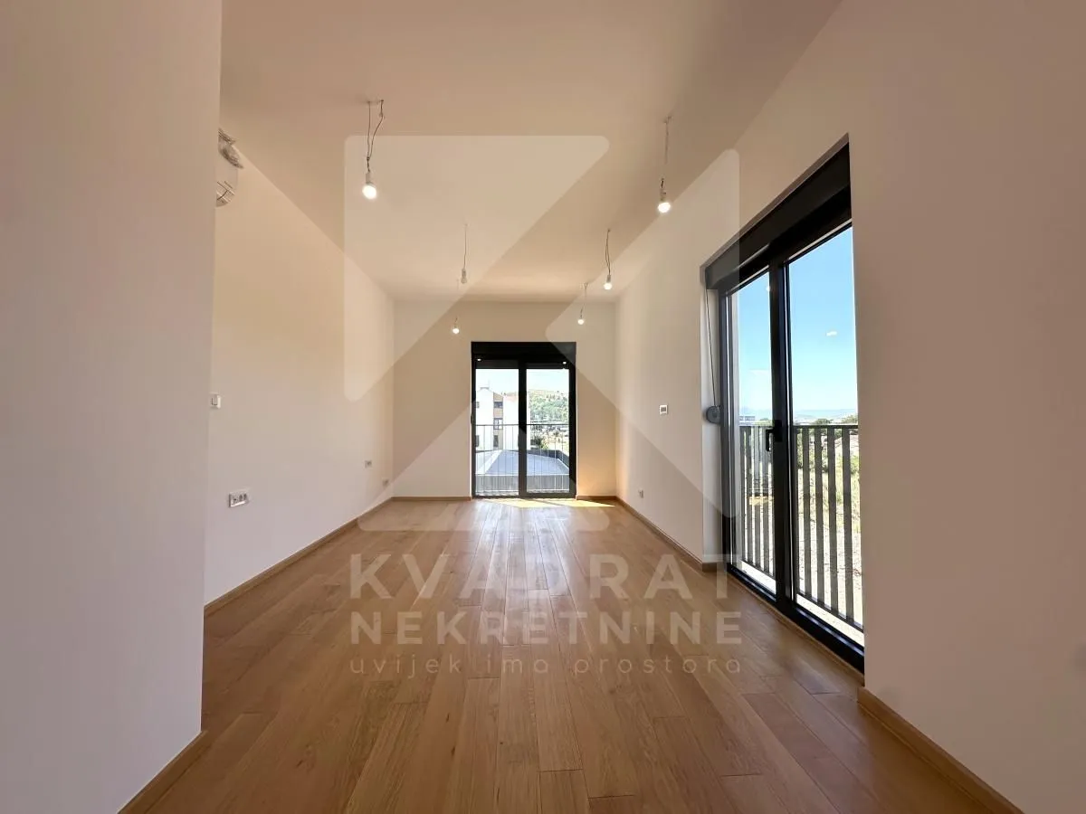 Empty room with wooden flooring and access to a terrace.