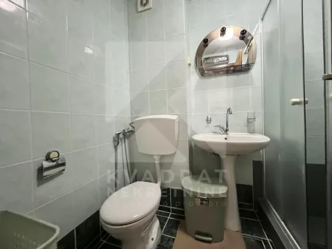 Small tiled bathroom with a sink, toilet, and shower cabin. - image 8