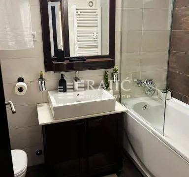 Modern bathroom with a washbasin, mirror and bathtub. - image 10