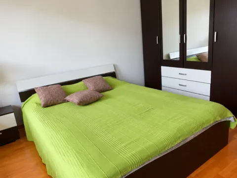 Furnished bedroom with a double bed and a large wardrobe. - image 8