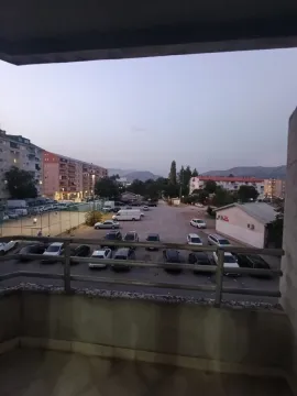Pogled sa balkona na parking i okolne zgrade u sumrak. - image 5