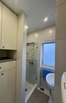 Pogled na kupatilo sa tuš kabinom, umivaonikom i ugrađenim elementima. - image 11