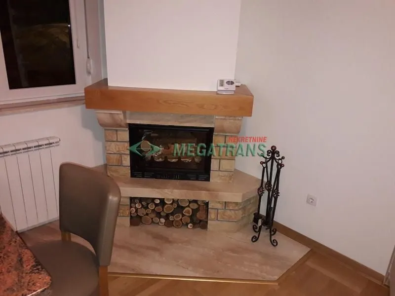 Corner fireplace in the living room with firewood storage.