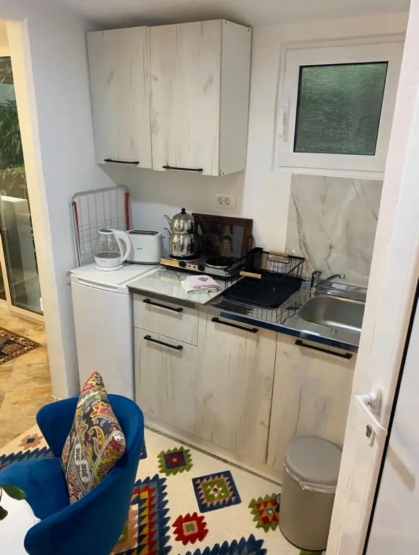 Small kitchen with white cabinets and a stove.