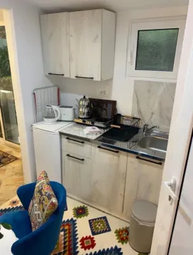 Small kitchen with white cabinets and a stove. - image 4