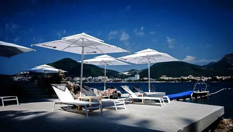 Pogled na uređenu plažu sa ležaljkama i suncobranima pored mora.