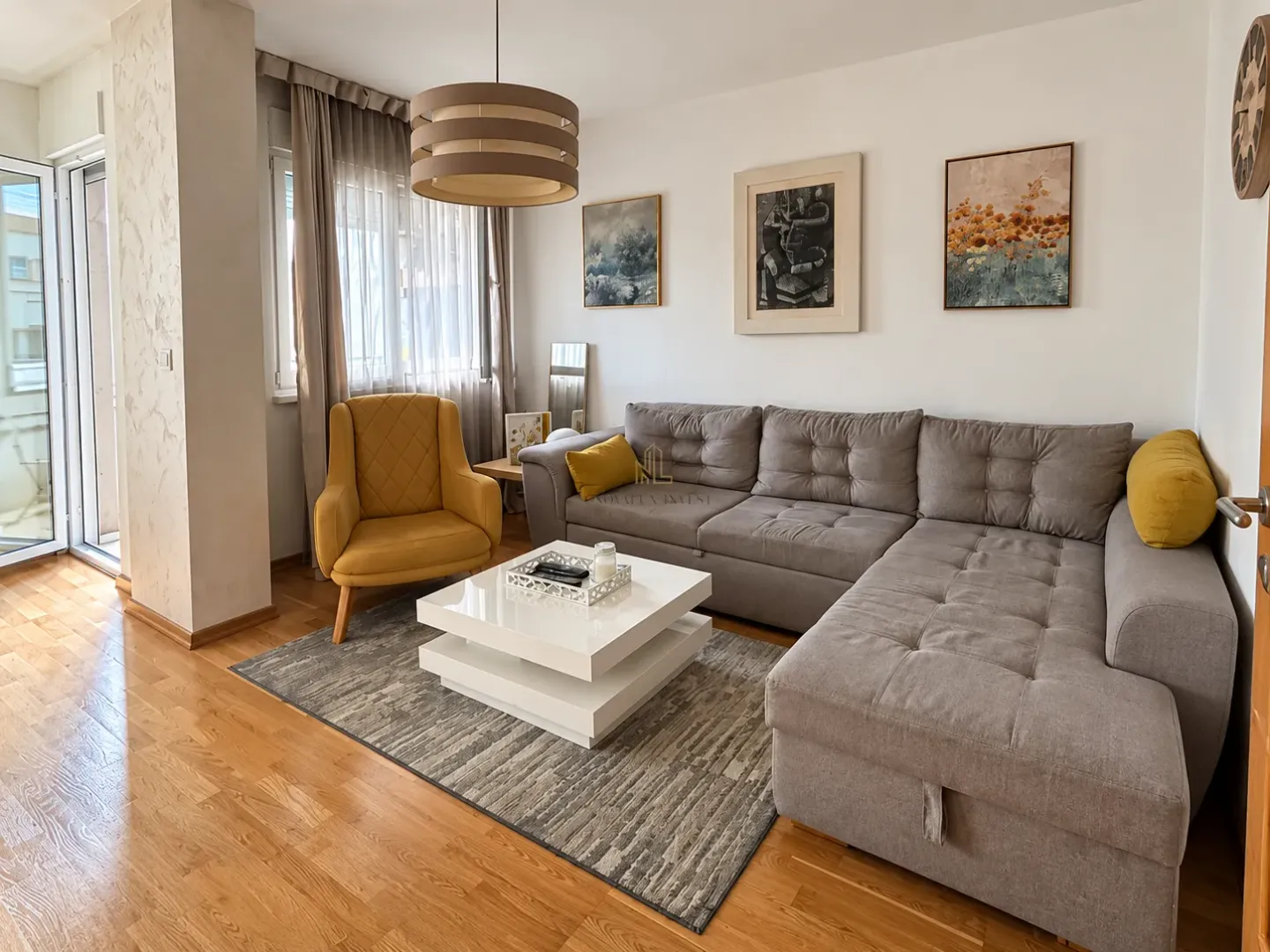 Living room with a sectional sofa, armchair, and access to the terrace.