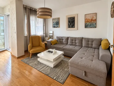 Living room with a sectional sofa, armchair, and access to the terrace. - image 2