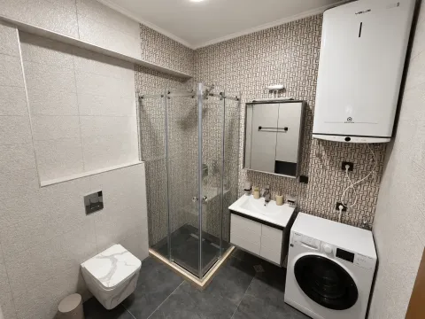 Kupatilo opremljeno tuš kabinom, umivaonikom, WC šoljom, bojlerom i veš mašinom. - image 6