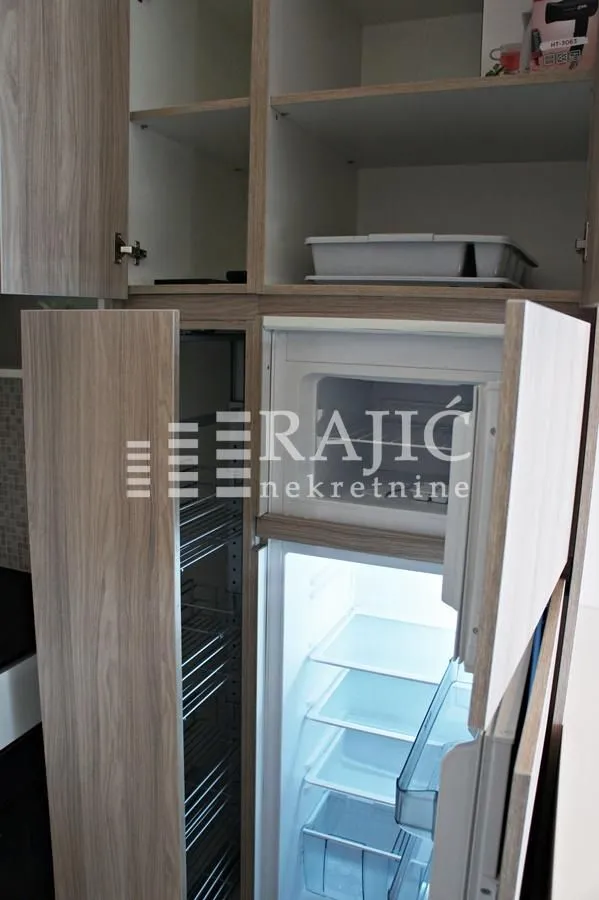 View of kitchen cabinets and refrigerator.