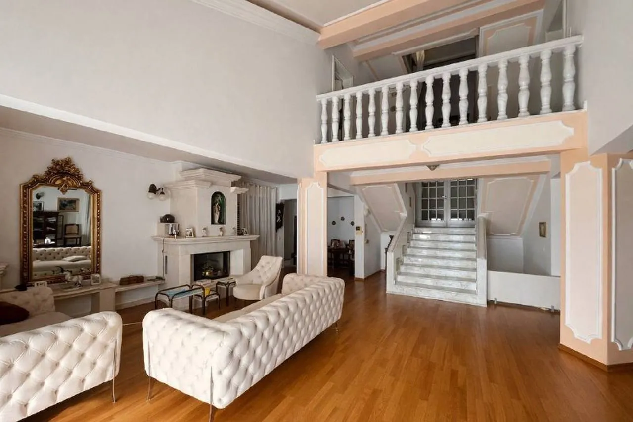 Spacious living room with a fireplace and indoor staircase.