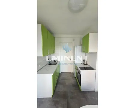 Small kitchen with white and green cabinetry and built-in appliances. - image 5