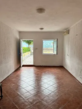 Empty room with tiled flooring and a view of the courtyard and sea through the door and window. - image 8