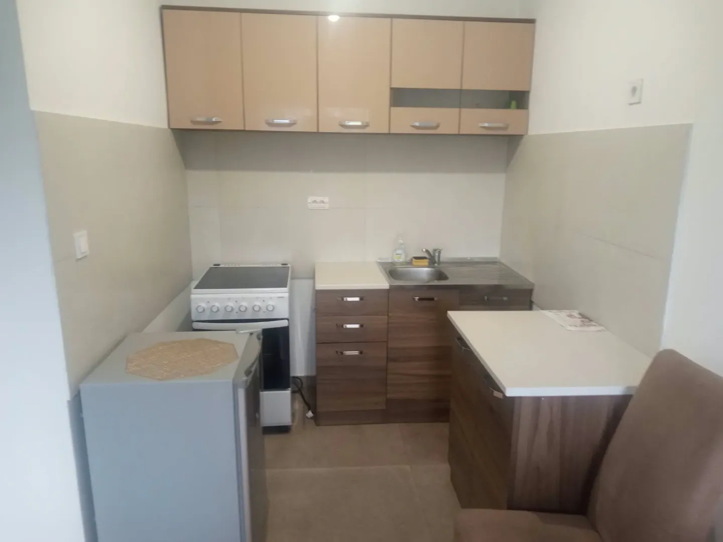 Small kitchen with wooden-tone cabinets and a stove.