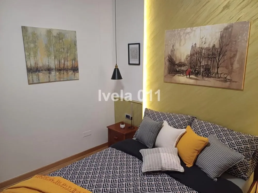 Modern bedroom with a double bed and decorative wall lighting.